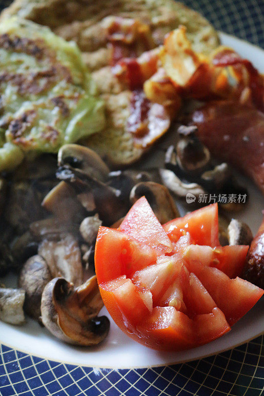 花切西红柿和蘑菇切片作为油炸早餐的一部分/煎培根，起泡和吱吱作响的法国吐司/鸡蛋面包，俯瞰